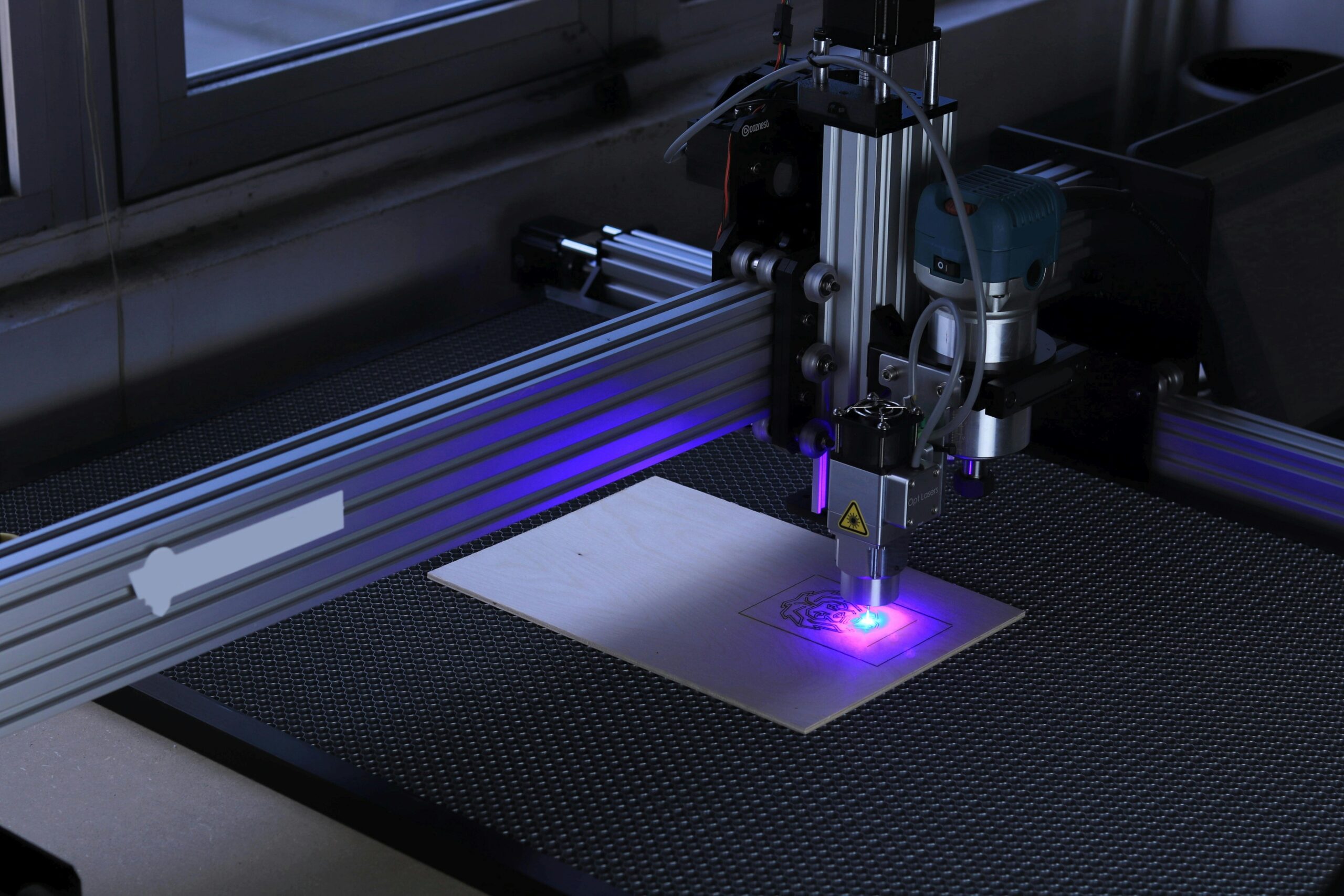 Close-up of a CNC laser engraving machine processing a wooden piece.